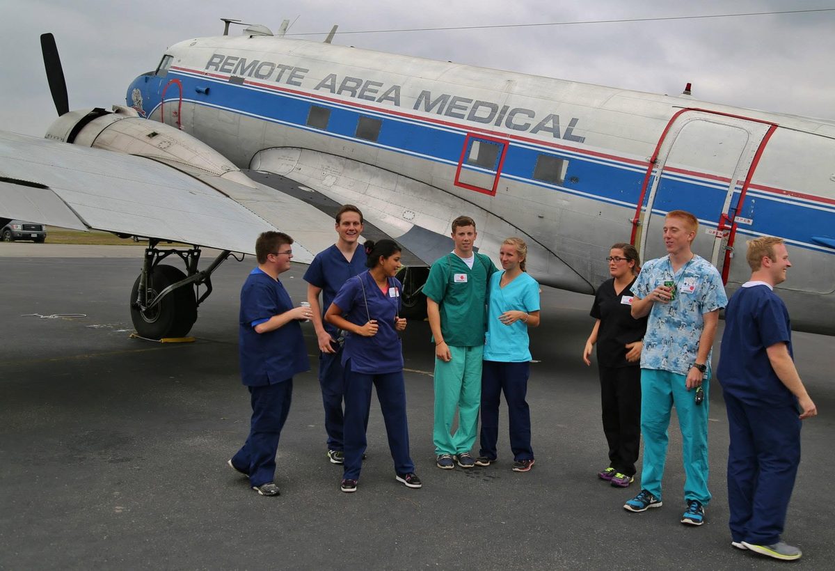 Remote Area Medical volunteer crew, including Zobia Zafar, beside the clinic aircraft